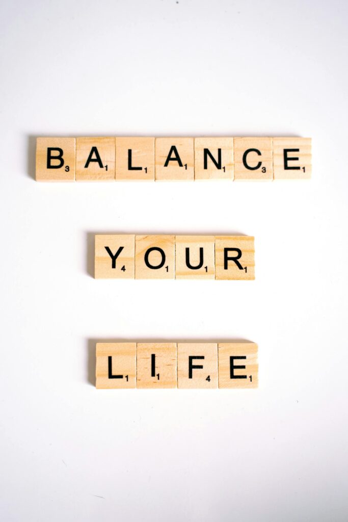 Motivational quote 'Balance Your Life' spelled with Scrabble tiles on white background.