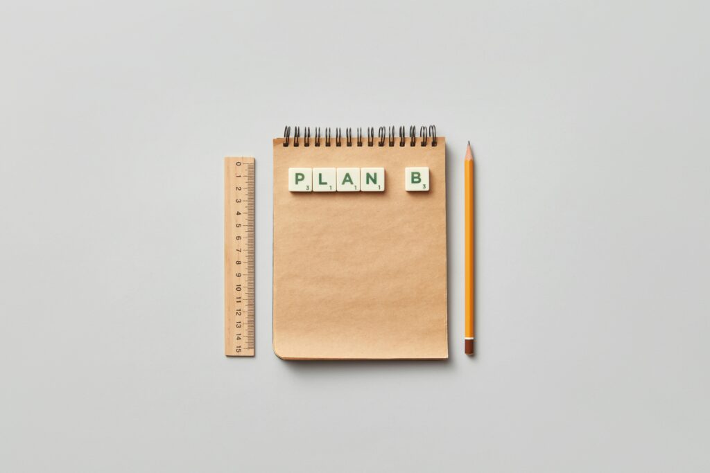 Minimalist flat lay of notepad, ruler, and pencil with Plan B tiles, perfect for creative work concepts.